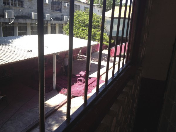 A view from the second floor of an employee spray painting the metal desks for the upcoming school year at Escuela Josefa Ortiz De Domingue in Culican, Sinaloa, Meixco